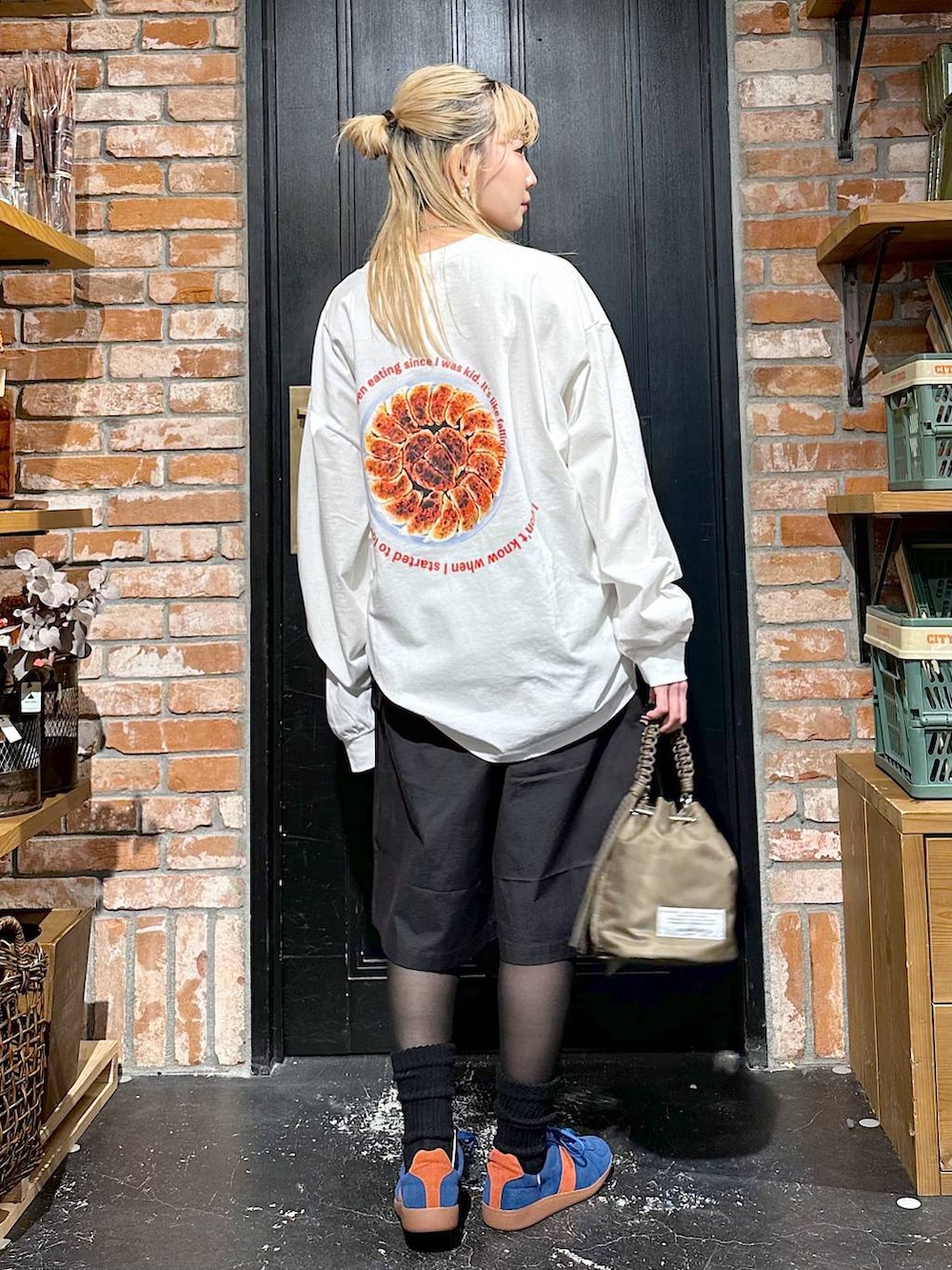 ブルー系のスニーカー、グリーン系のショルダーバッグ、その他のTシャツ/カットソーを着用したレディースの冬コーディネートの3枚目の写真