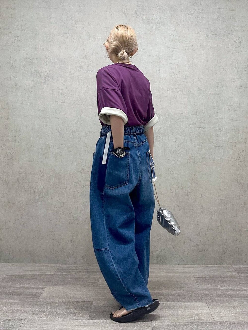 シルバー系のショルダーバッグ、パープル系のTシャツ/カットソー、ブルー系のデニムパンツを着用したレディースの春コーディネートの3枚目の写真