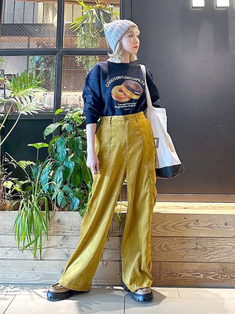 ブラック系のトートバッグ、イエロー系のモカシン/デッキシューズ、イエロー系のカーゴパンツを着用したレディースの秋コーディネートの4枚目の写真