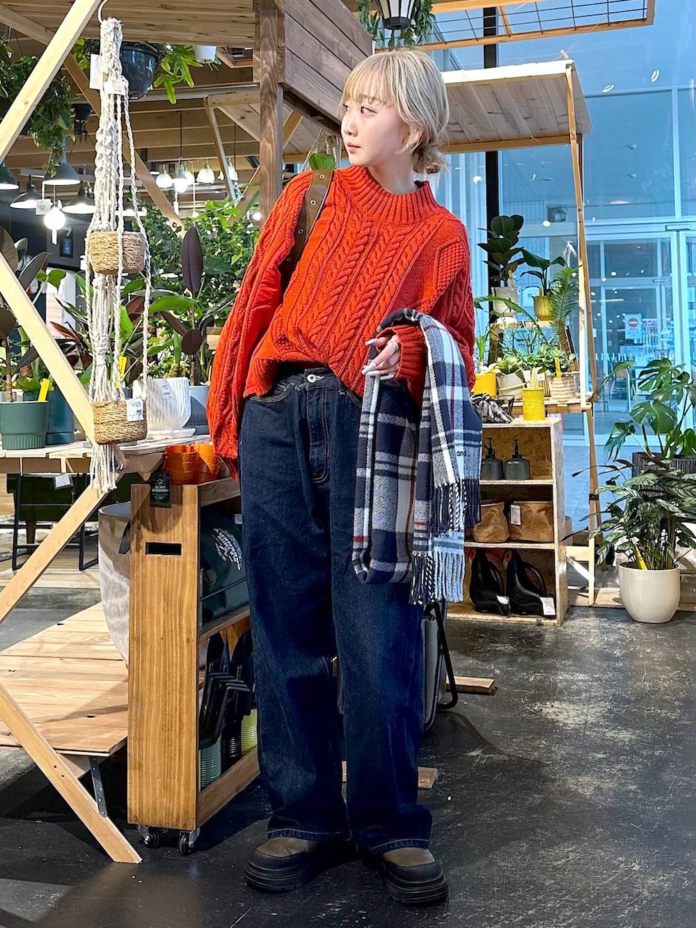 ブルー系のデニムパンツ、ブラウン系のブーツ、ブラウン系のショルダーバッグを着用したレディースの冬コーディネートの3枚目の写真