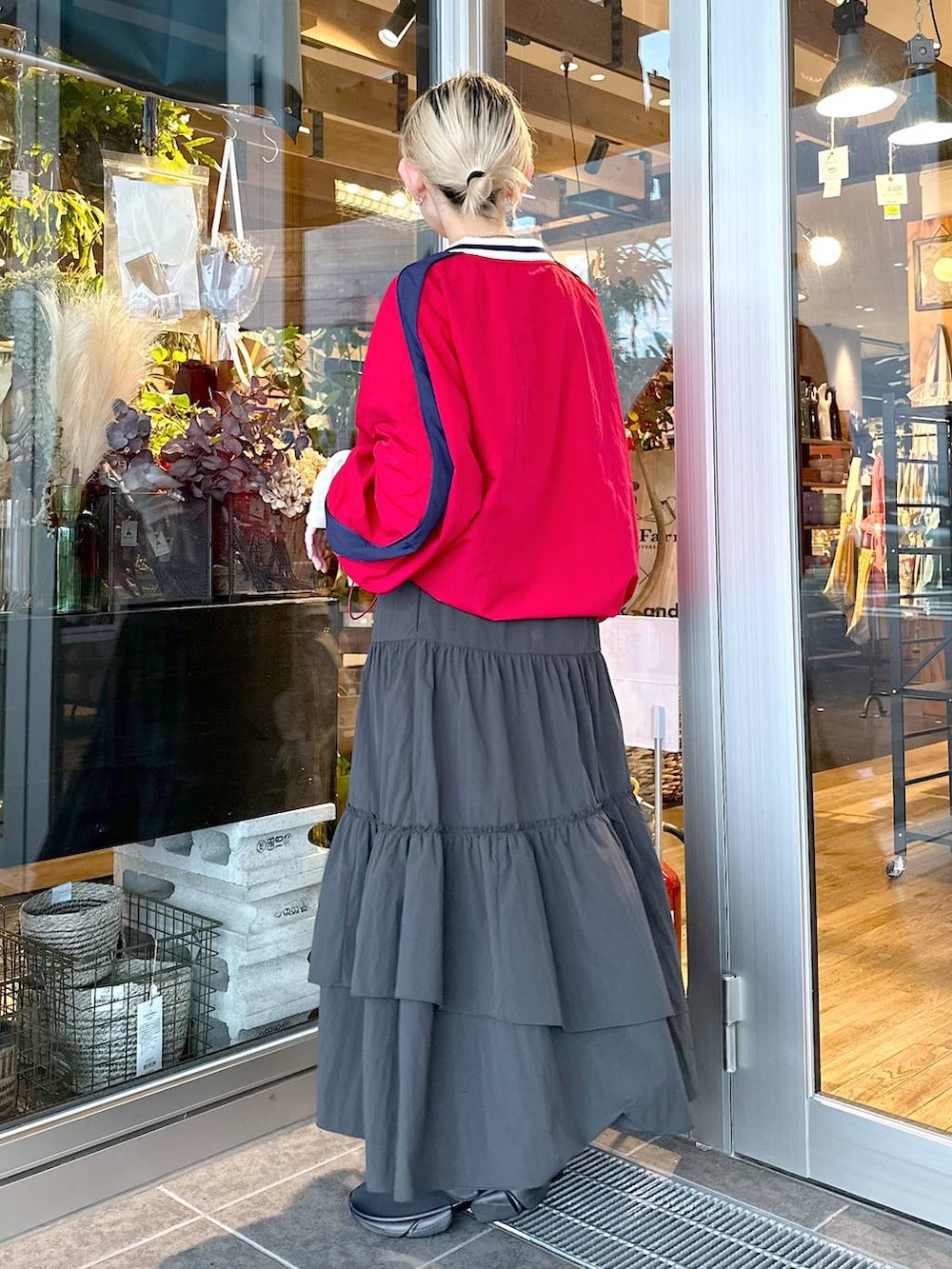 ベージュ系のトートバッグ、ブラック系のスニーカー、ブラック系のスカートを着用したレディースの秋コーディネートの3枚目の写真