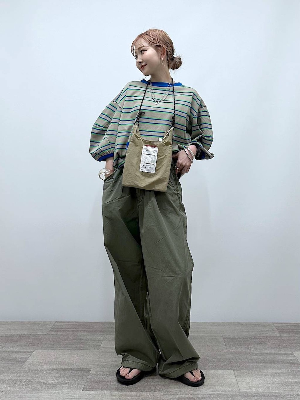 ベージュ系のショルダーバッグ、ベージュ系のTシャツ/カットソー、グリーン系のその他パンツを着用したレディースの夏コーディネートの2枚目の写真