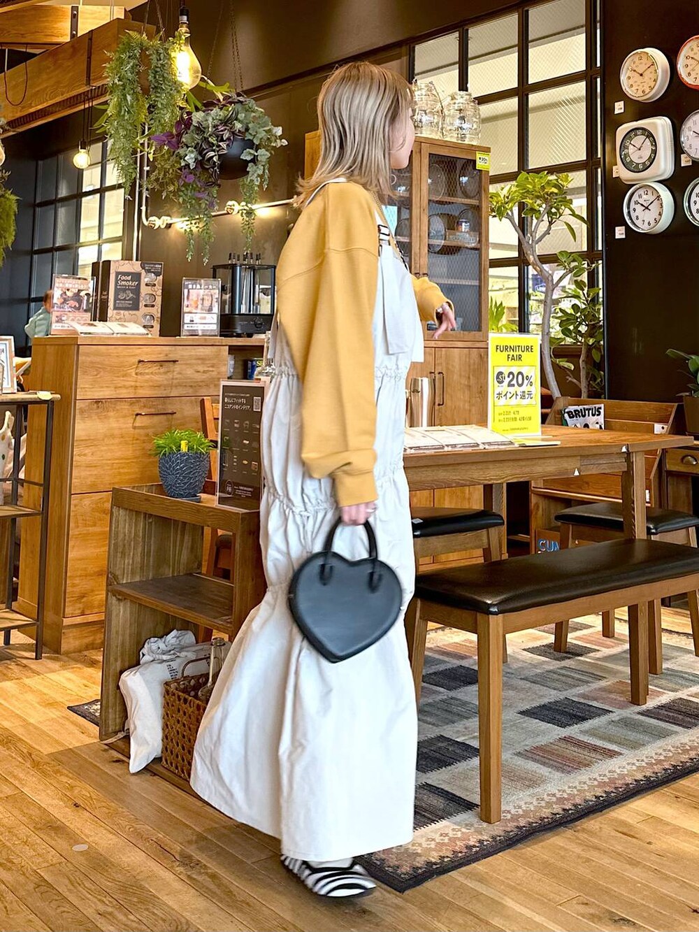 イエロー系のスウェット、その他のパンプス、ブラック系のショルダーバッグを着用したレディースの冬コーディネートの2枚目の写真