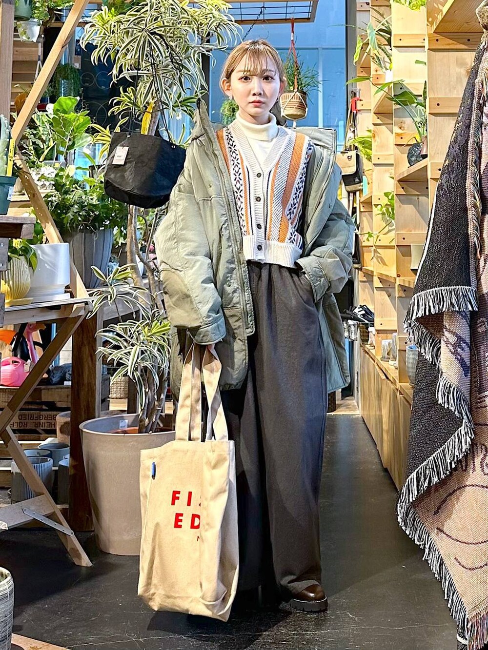 グレー系のその他パンツ、グリーン系のブルゾン、ベージュ系のニット/セーターを着用したレディースの冬コーディネートの4枚目の写真