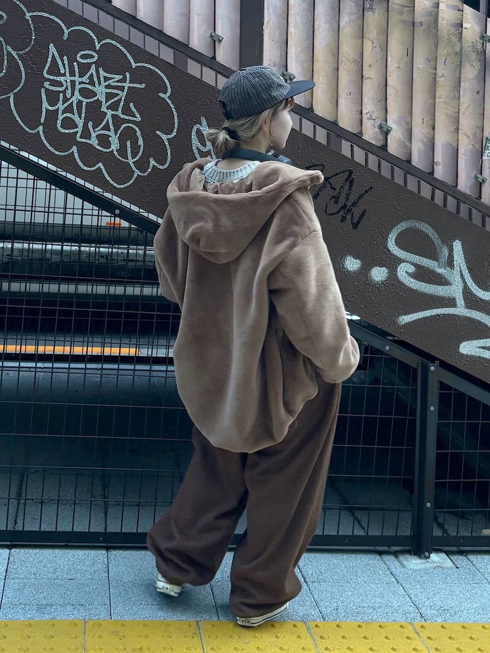 ブラウン系のブルゾン、グレー系のニット/セーター、ブラウン系のその他パンツを着用したレディースの秋コーディネートの2枚目の写真