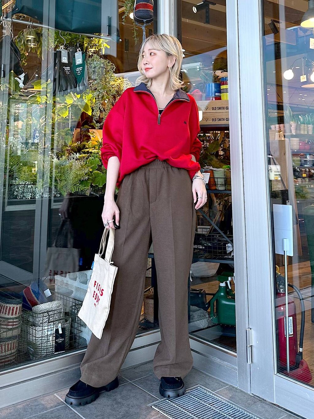 イエロー系のモカシン/デッキシューズ、レッド系のスウェット、ブラウン系のその他パンツを着用したレディースの秋コーディネートの2枚目の写真