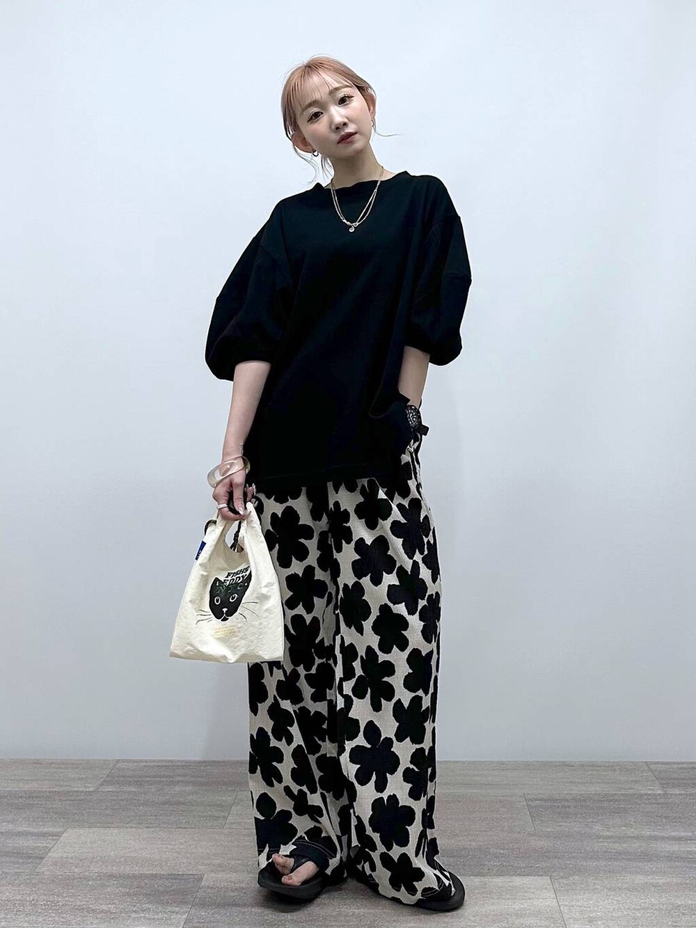 ホワイト系のショルダーバッグ、ブラック系のTシャツ/カットソー、ブラック系のサンダルを着用したレディースの春コーディネートの4枚目の写真