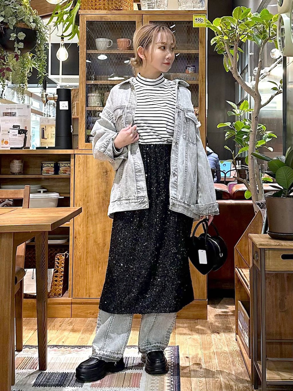ブラック系のローファー、ブラック系のスカート、ブラック系のショルダーバッグを着用したレディースの冬コーディネートの3枚目の写真