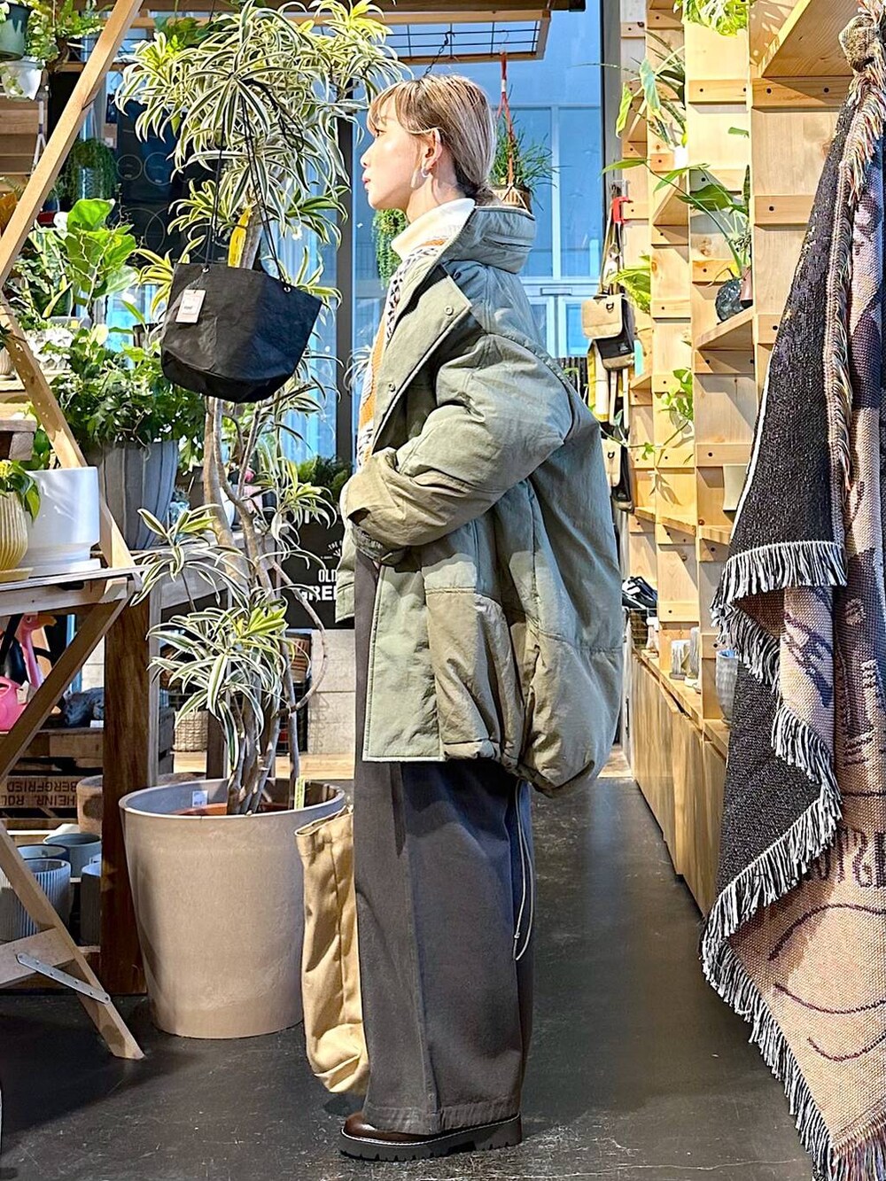 グレー系のその他パンツ、グリーン系のブルゾン、ベージュ系のニット/セーターを着用したレディースの冬コーディネートの2枚目の写真