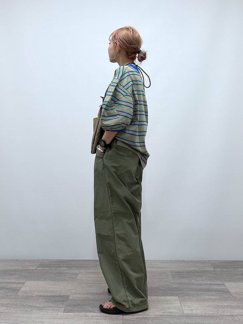 ベージュ系のショルダーバッグ、ベージュ系のTシャツ/カットソー、グリーン系のその他パンツを着用したレディースの夏コーディネートの3枚目の写真