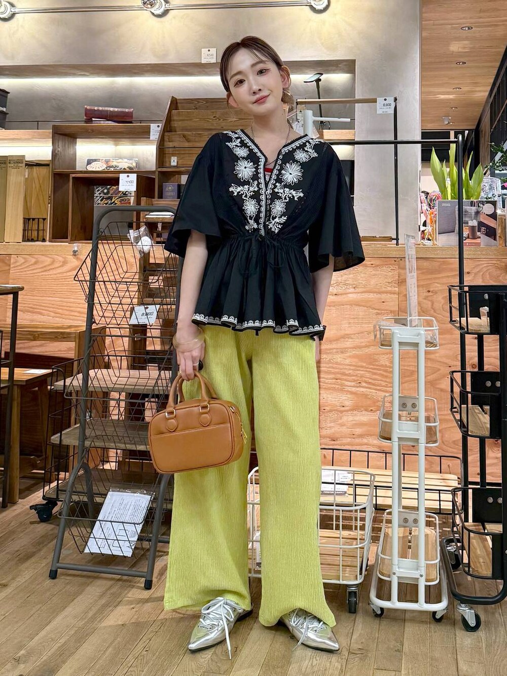 イエロー系のその他パンツ、グレー系のサンダル、イエロー系のボストンバッグを着用したレディースの夏コーディネートの3枚目の写真