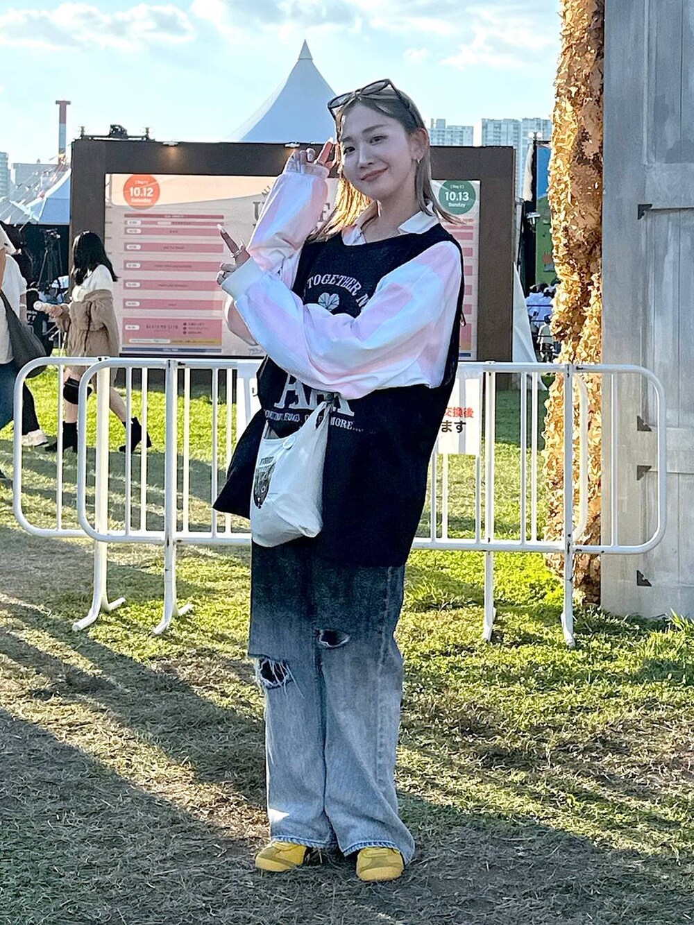 ホワイト系のショルダーバッグ、ブラック系のデニムパンツ、その他のTシャツ/カットソーを着用したレディースの秋コーディネートの2枚目の写真