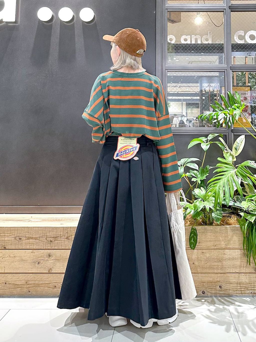 グレー系のスニーカー、グリーン系のTシャツ/カットソー、ベージュ系のトートバッグを着用したレディースの秋コーディネートの2枚目の写真