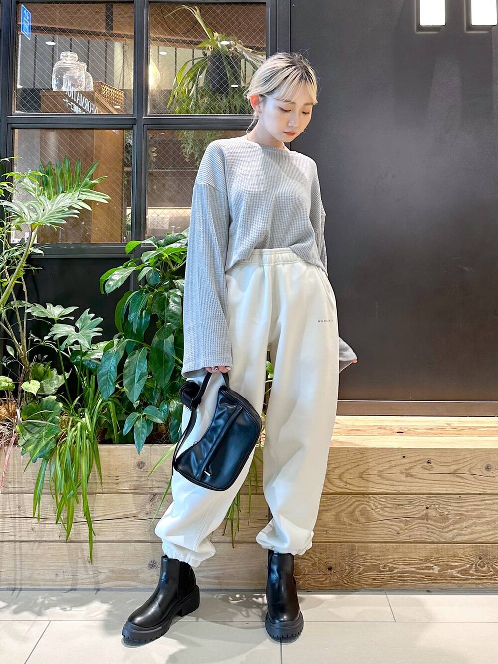 ブラック系のショルダーバッグ、その他のスウェットパンツ、ブラック系のブーツを着用したレディースの秋コーディネートの3枚目の写真