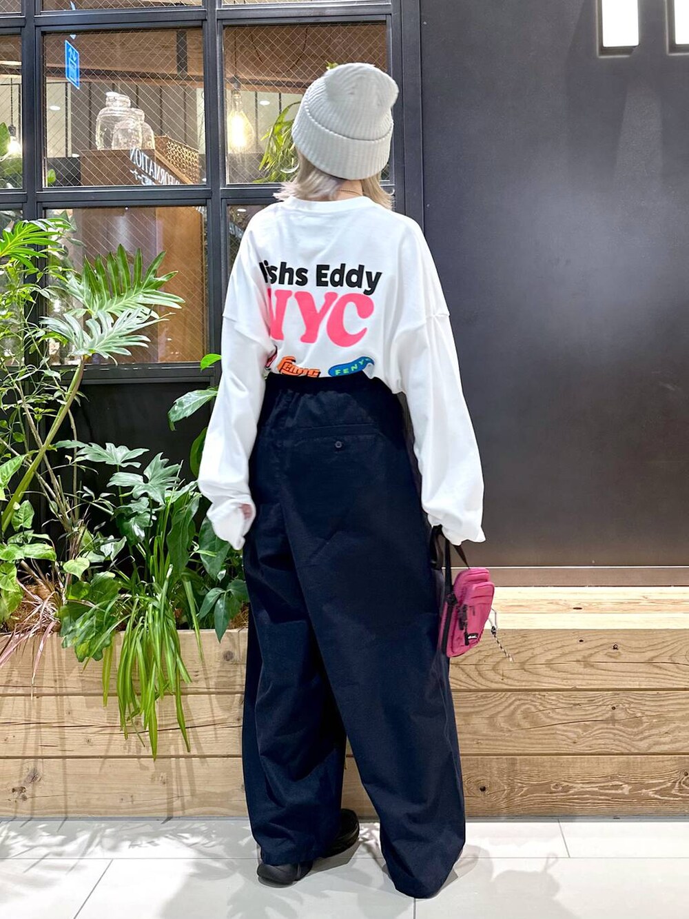 パープル系のショルダーバッグ、ブルー系のチノパンツ、ブラック系のスニーカーを着用したレディースの秋コーディネートの2枚目の写真