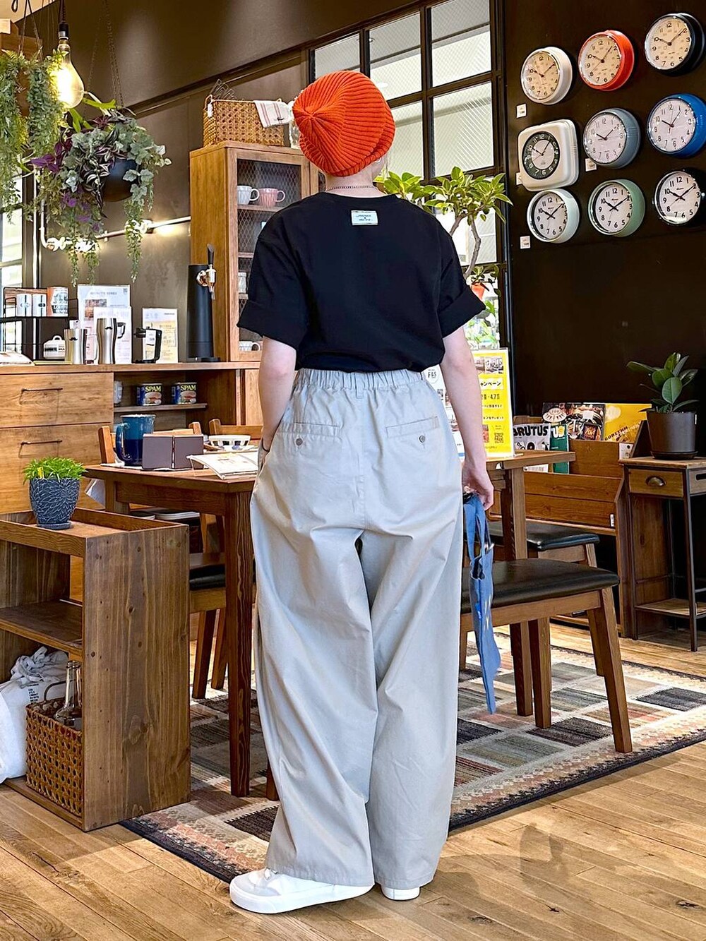 ホワイト系のスニーカー、グレー系のチノパンツ、ブルー系のトートバッグを着用したレディースの冬コーディネートの2枚目の写真