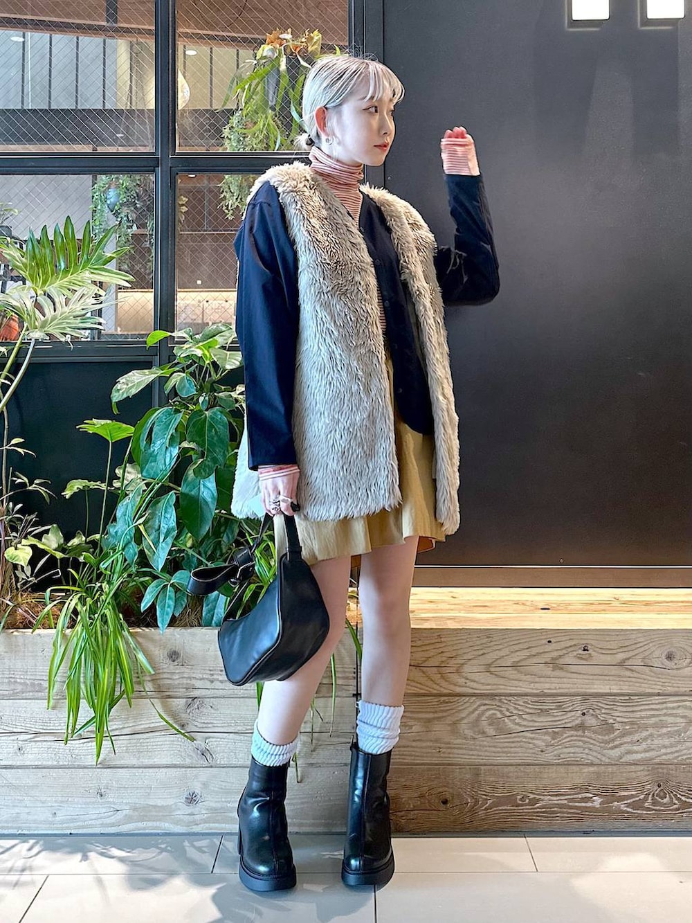 ブルー系のカーディガン/ボレロ、ベージュ系のベスト、レッド系のTシャツ/カットソーを着用したレディースの秋コーディネートの2枚目の写真
