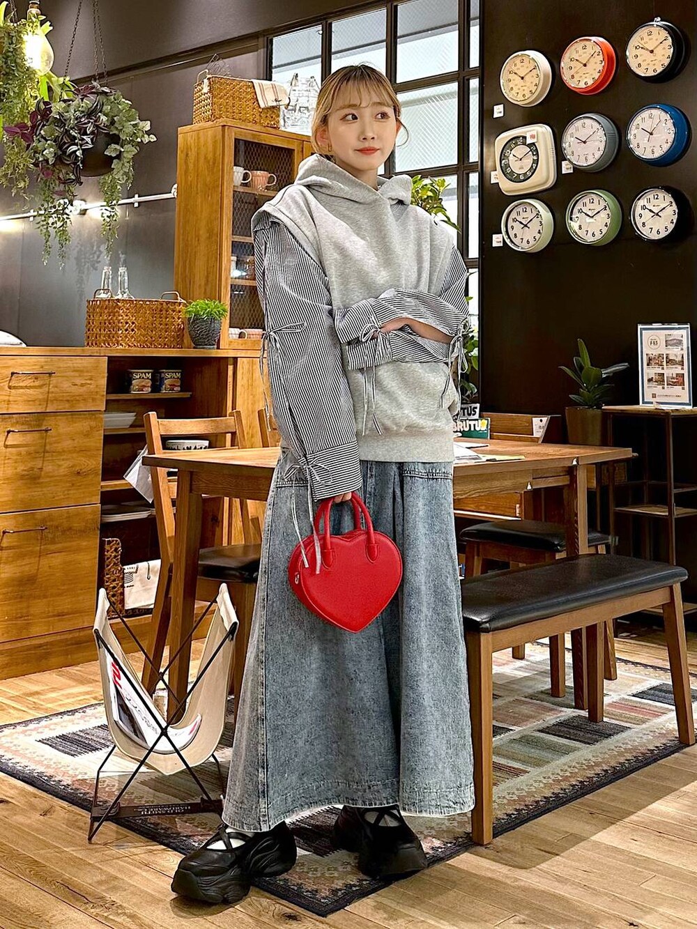 ブラック系のスニーカー、レッド系のショルダーバッグ、ブルー系のスカートを着用したレディースの冬コーディネートの2枚目の写真