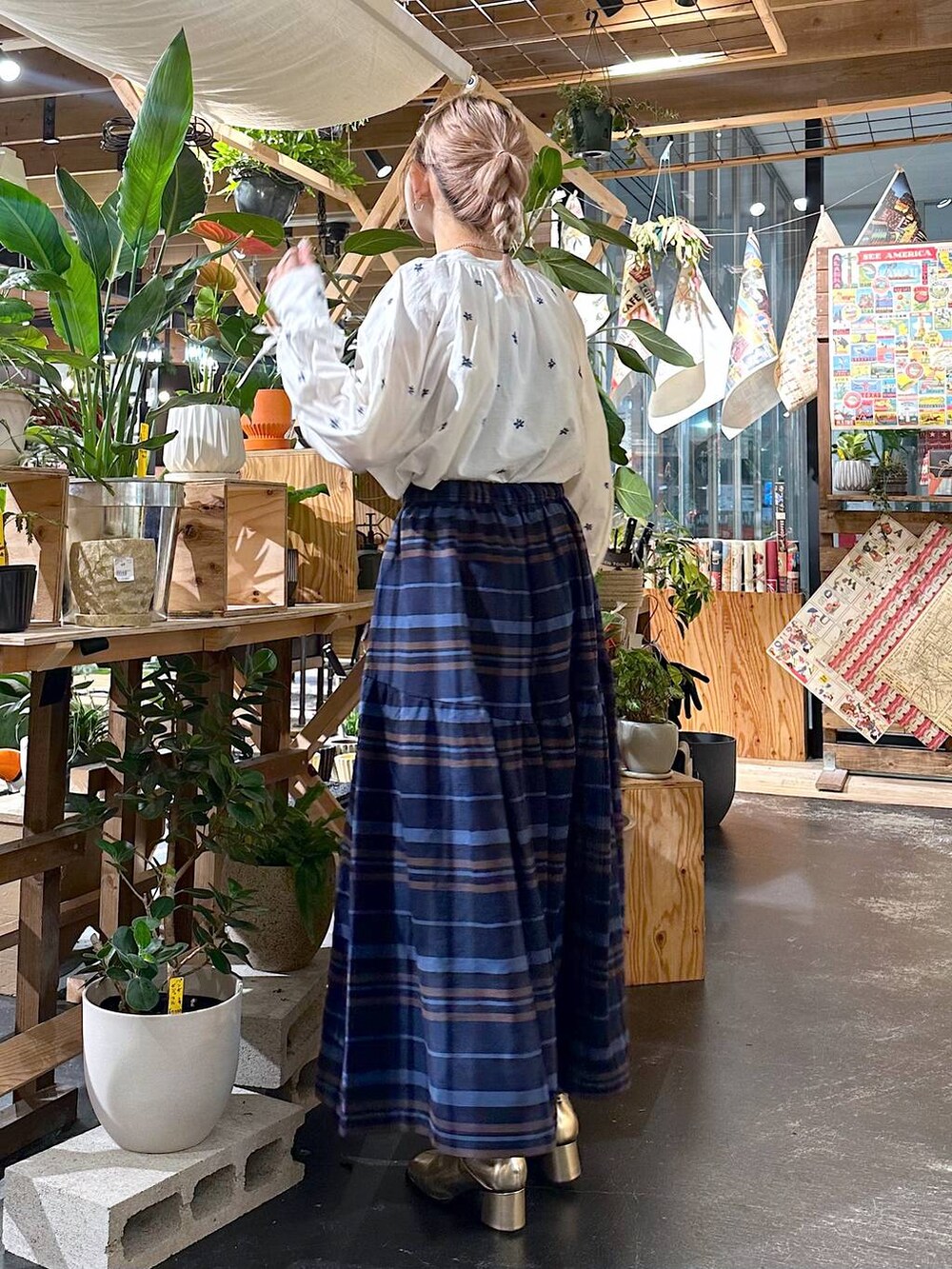 ブルー系のその他パンツ、ゴールド系のブーツ、ブラウン系のショルダーバッグを着用したレディースの夏コーディネートの3枚目の写真