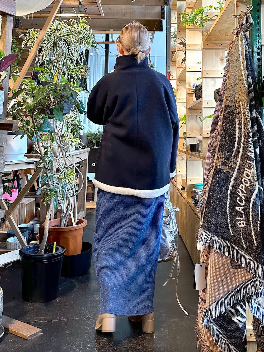 ブルー系のブルゾン、ベージュ系のブーツ、グレー系のショルダーバッグを着用したレディースの冬コーディネートの4枚目の写真