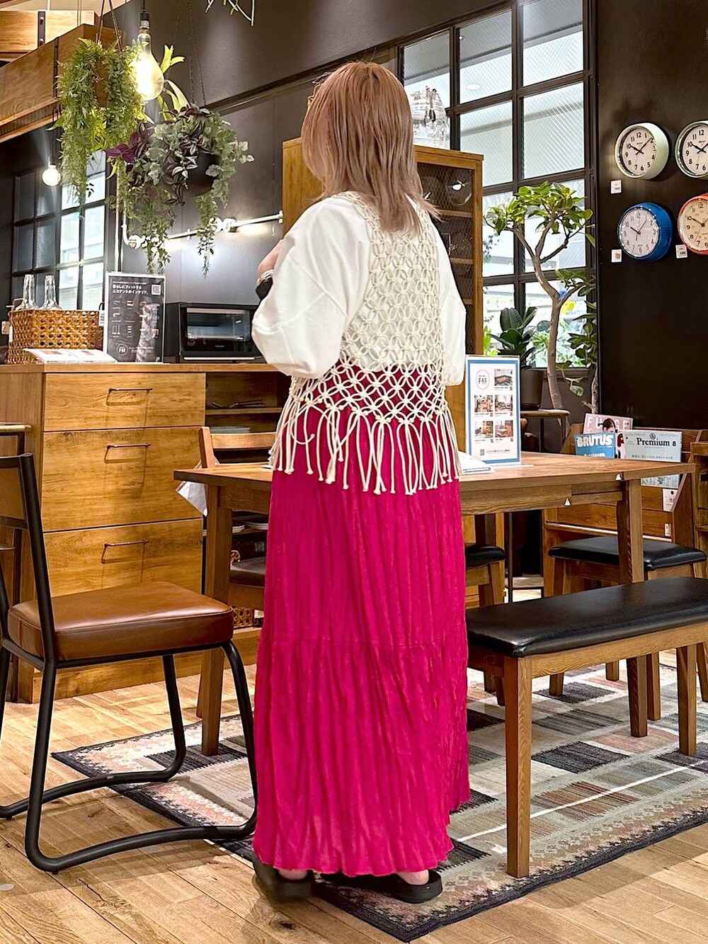 ブラック系のショルダーバッグ、ピンク系のスカート、ホワイト系のTシャツ/カットソーを着用したレディースの春コーディネートの2枚目の写真