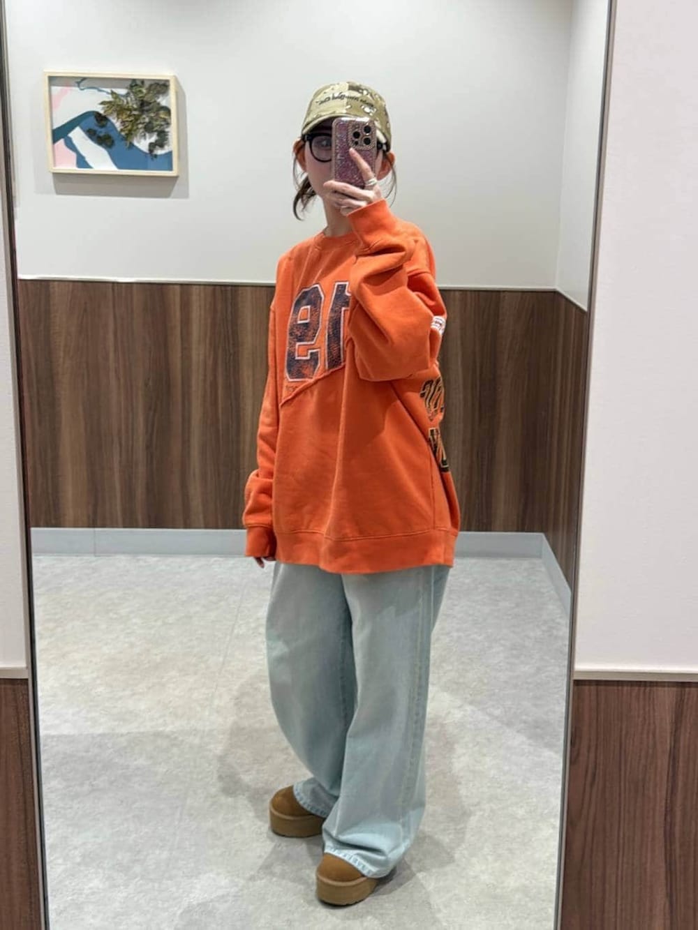 ブルー系のトートバッグ、ブルー系のデニムパンツ、オレンジ系のスウェットを着用したレディースの冬コーディネートの2枚目の写真