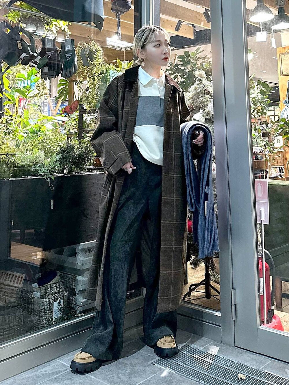 ブラウン系のステンカラーコート、イエロー系のモカシン/デッキシューズ、ブラック系のカーゴパンツを着用したレディースの秋コーディネートの3枚目の写真