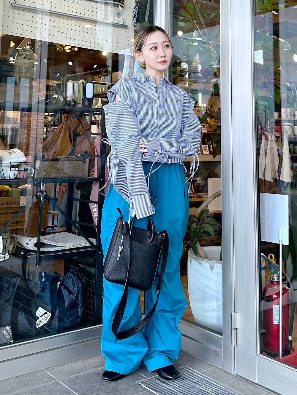 ブラック系のトートバッグ、その他のパンプス、ブルー系のシャツ/ブラウスを着用したレディースの春コーディネートの4枚目の写真
