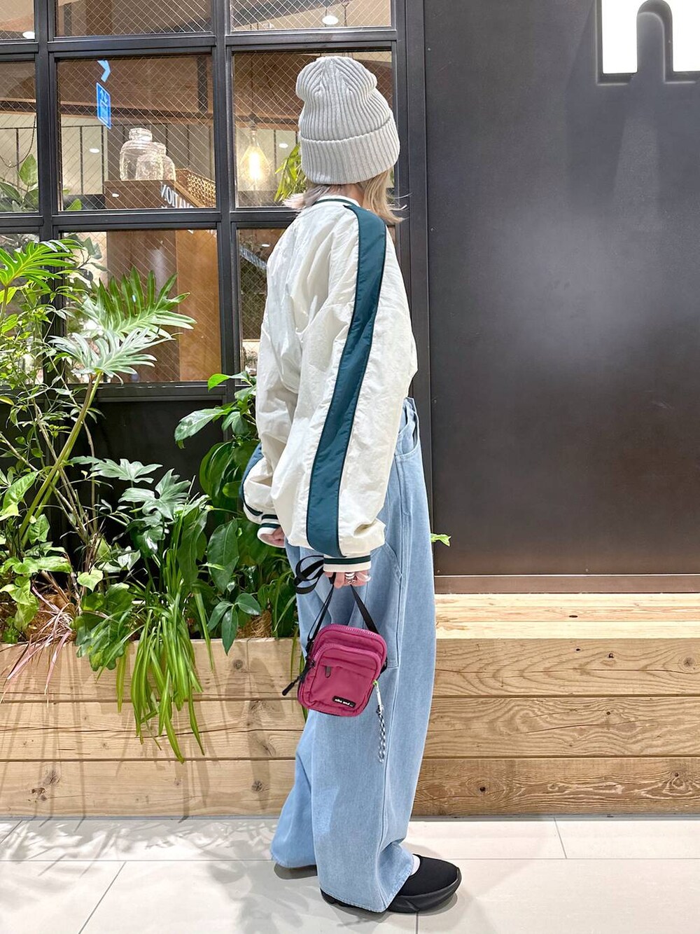パープル系のショルダーバッグ、ブルー系のその他パンツ、ブラック系のスニーカーを着用したレディースの秋コーディネートの3枚目の写真