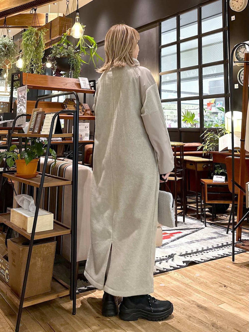 ブラック系のブーツ、ベージュ系のワンピース、グレー系のショルダーバッグを着用したレディースの冬コーディネートの2枚目の写真
