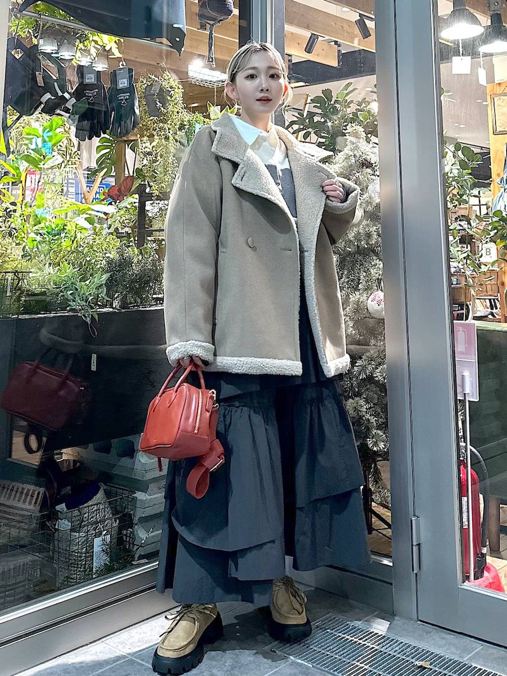 ブラウン系のブルゾン、イエロー系のモカシン/デッキシューズ、ブラウン系のショルダーバッグを着用したレディースの秋コーディネートの2枚目の写真