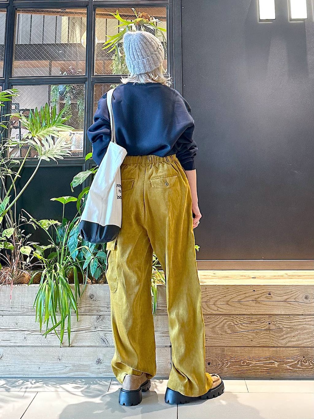 ブラック系のトートバッグ、イエロー系のモカシン/デッキシューズ、イエロー系のカーゴパンツを着用したレディースの秋コーディネートの3枚目の写真