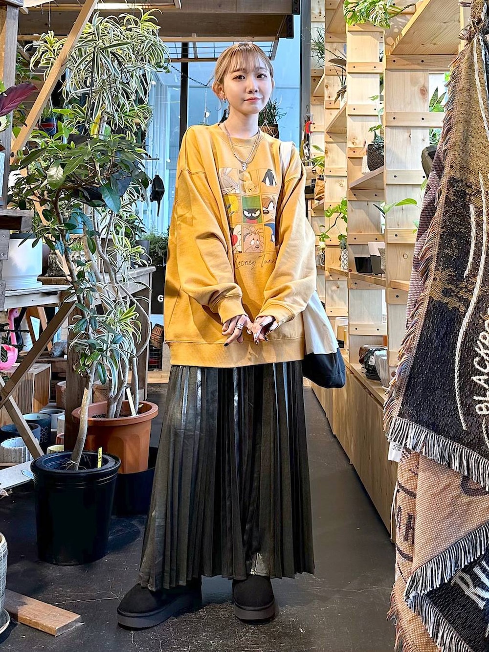 ブラック系のトートバッグ、ブラック系のブーツ、イエロー系のスウェットを着用したレディースの冬コーディネートの4枚目の写真