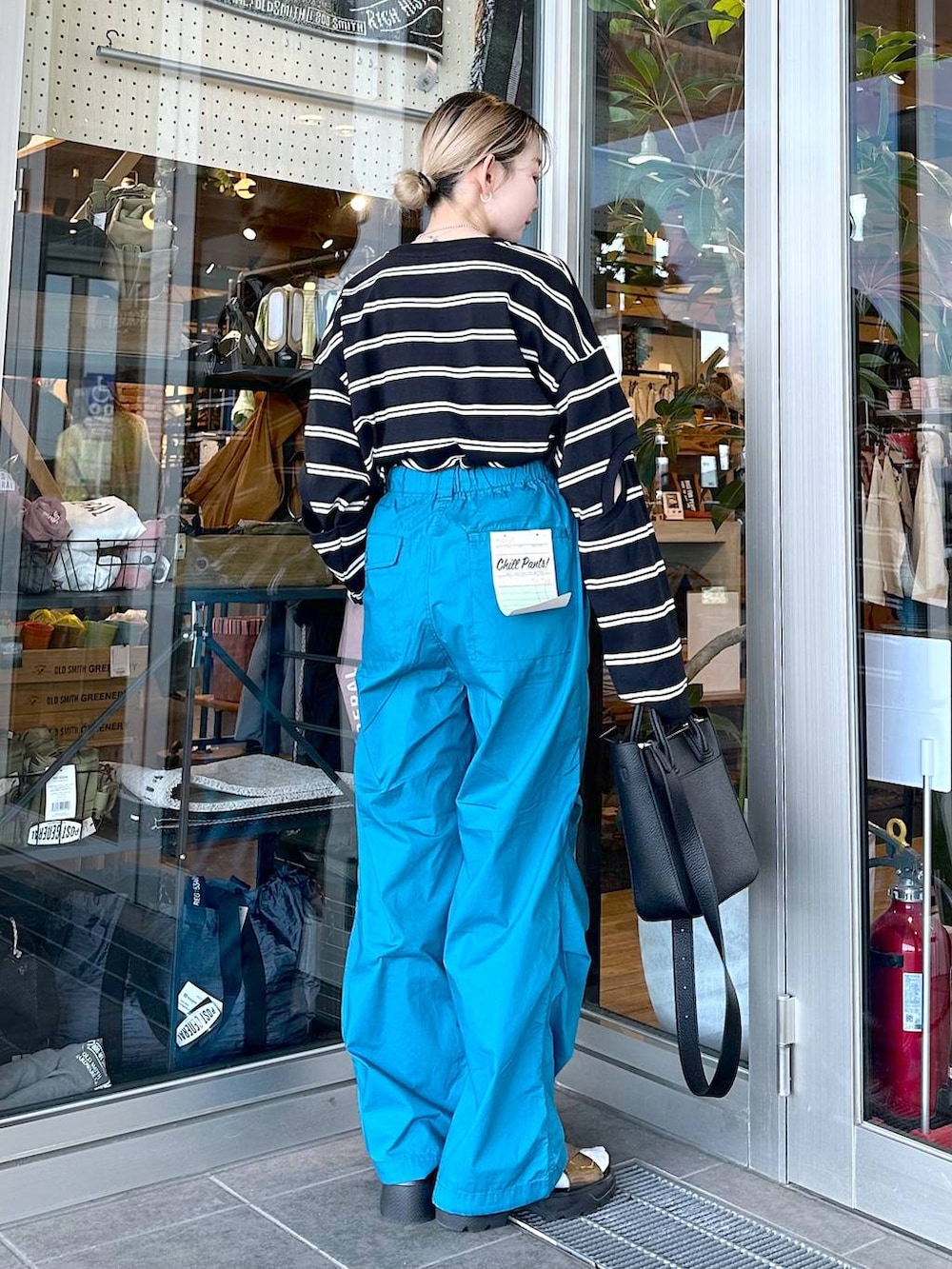 その他のサンダル、ブラック系のトートバッグ、ブラック系のTシャツ/カットソーを着用したレディースの春コーディネートの3枚目の写真