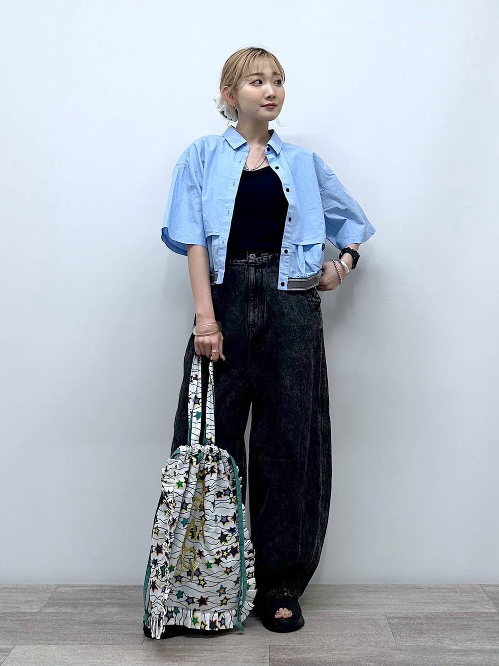 ブラック系のサンダル、ホワイト系のトートバッグ、ブラック系のデニムパンツを着用したレディースの夏コーディネートの2枚目の写真