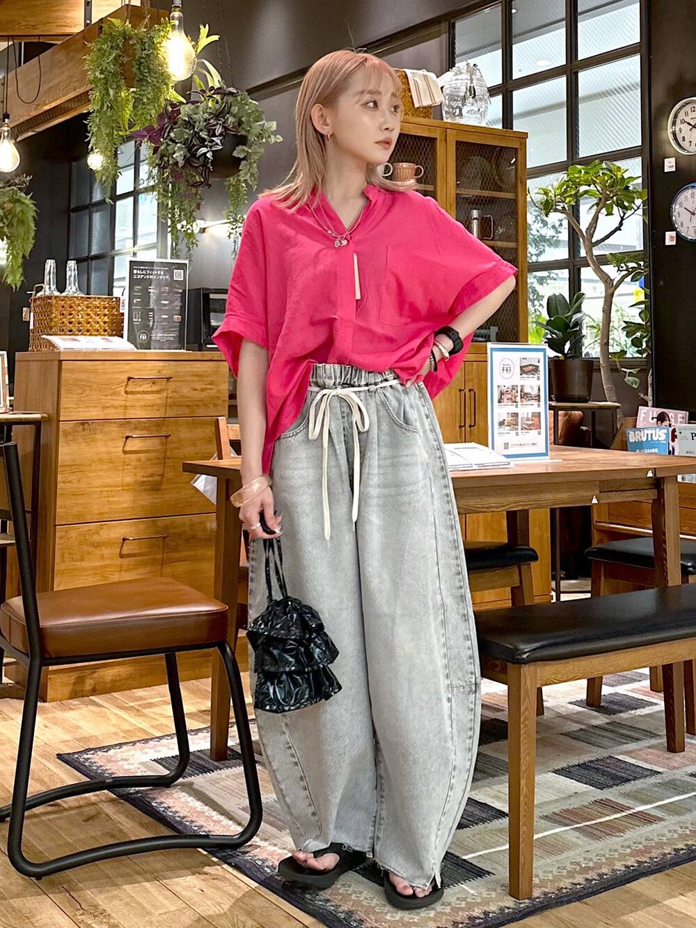 ブラック系のショルダーバッグ、グレー系のデニムパンツ、ブラック系のサンダルを着用したレディースの春コーディネートの4枚目の写真