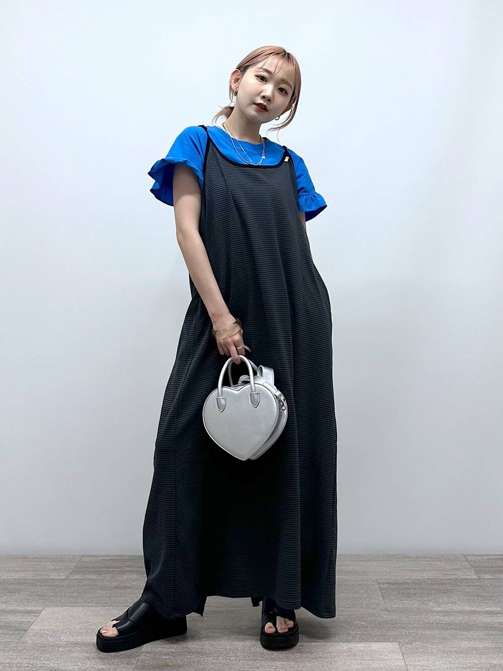 シルバー系のショルダーバッグ、ブルー系のTシャツ/カットソー、ブラック系のサンダルを着用したレディースの夏コーディネートの3枚目の写真