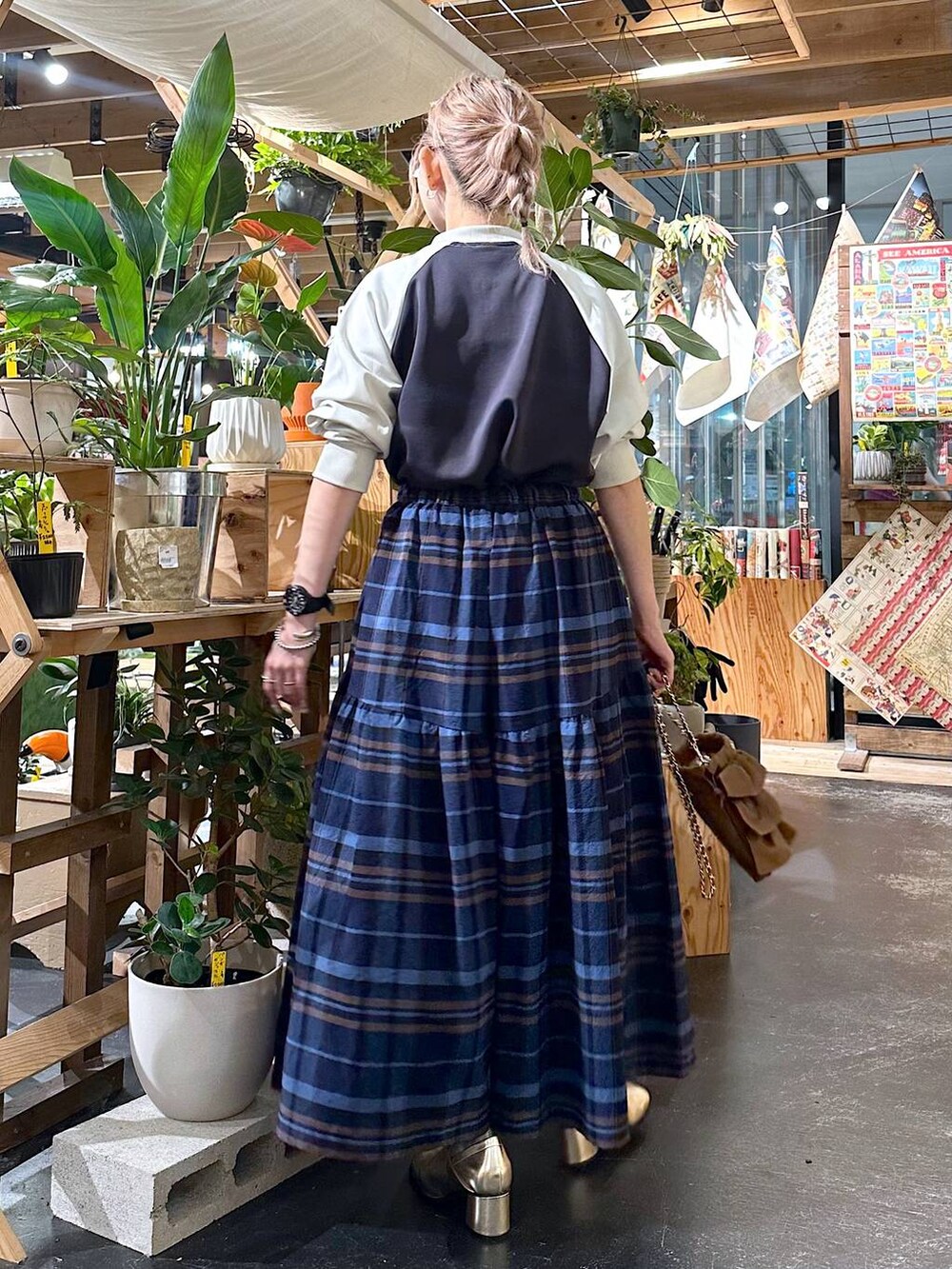 グレー系のその他パンツ、ゴールド系のブーツ、ブラウン系のショルダーバッグを着用したレディースの夏コーディネートの2枚目の写真