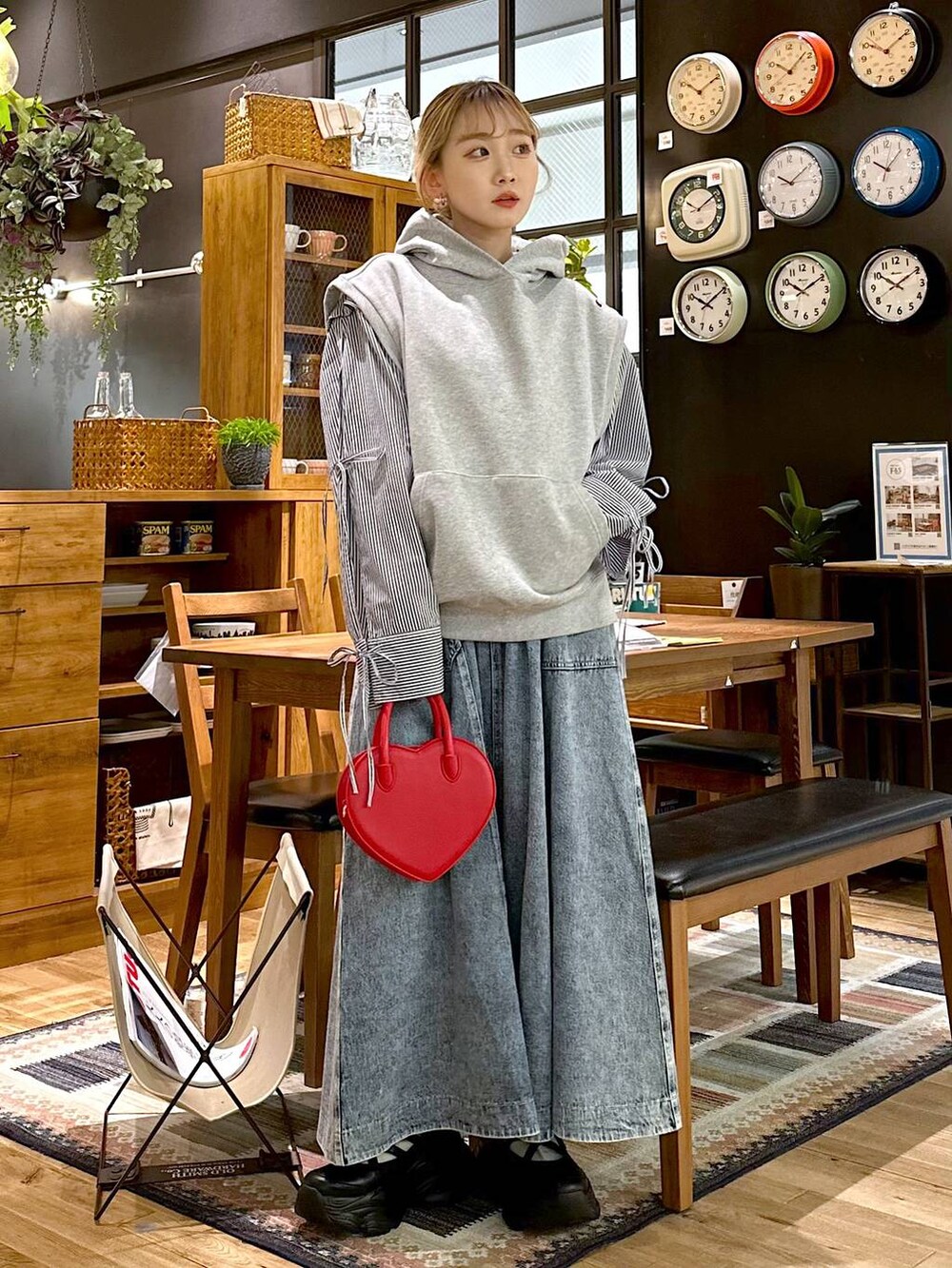 ブラック系のスニーカー、レッド系のショルダーバッグ、ブルー系のスカートを着用したレディースの冬コーディネートの5枚目の写真