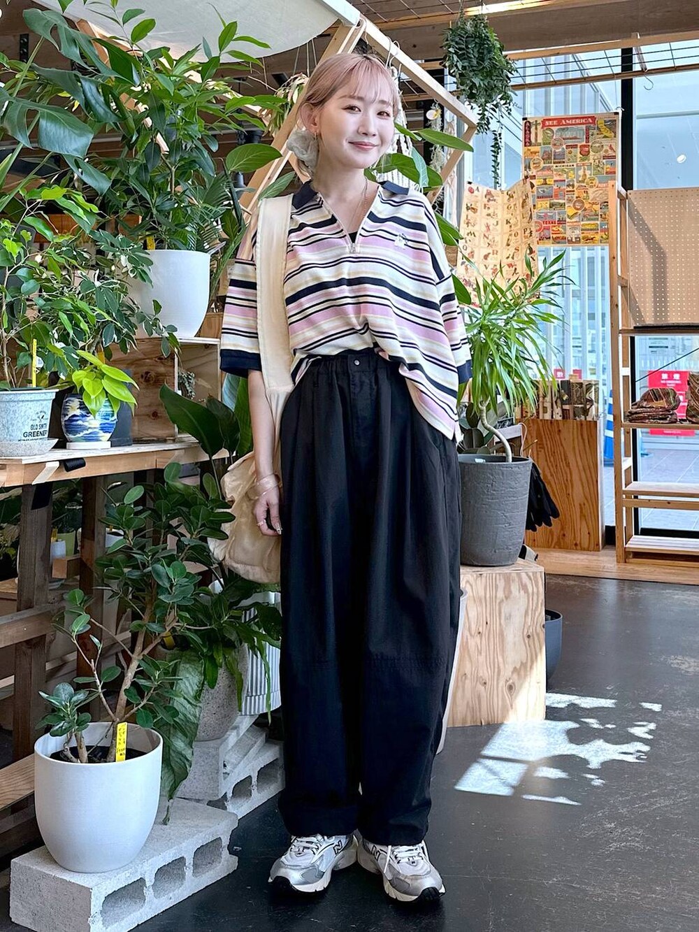 ブラック系のその他パンツ、ベージュ系のポロシャツ、ベージュ系のショルダーバッグを着用したレディースの夏コーディネートの2枚目の写真