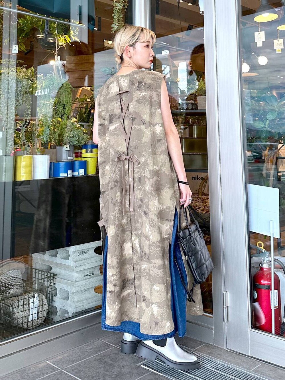 ブラック系のショルダーバッグ、ブラック系のキャミソール、グレー系のブーツを着用したレディースの秋コーディネートの3枚目の写真