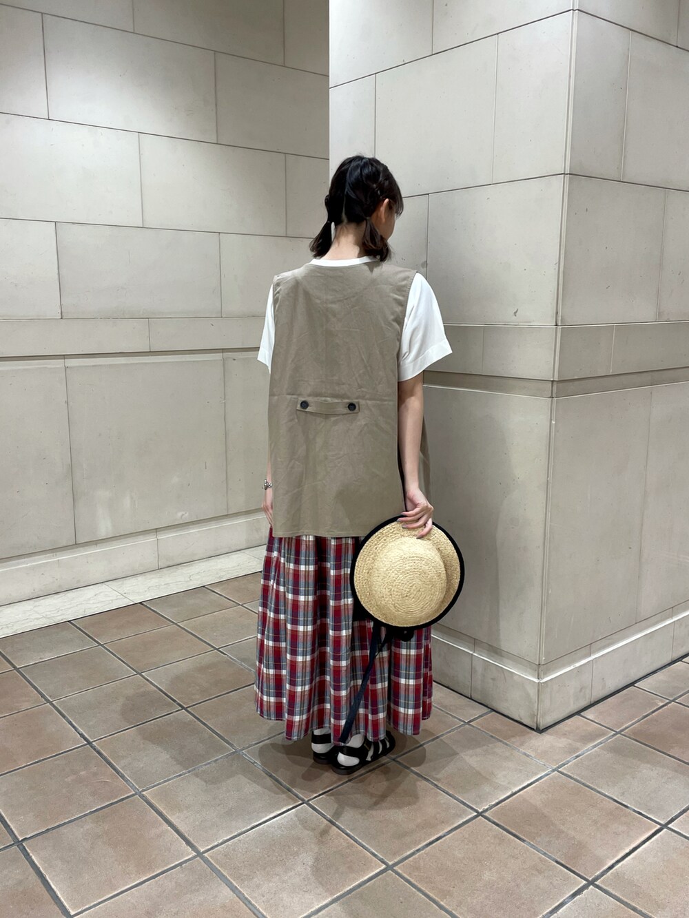 ホワイト系のTシャツ/カットソー、ベージュ系のベスト、レッド系のスカートを着用したレディースの春コーディネートの2枚目の写真