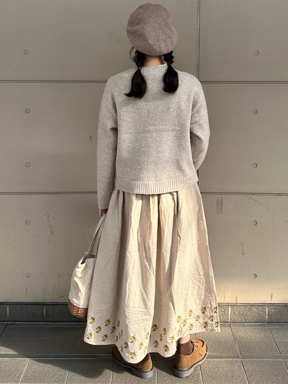 ベージュ系のカーディガン/ボレロ、ベージュ系のスカート、ベージュ系のハンドバッグを着用したレディースの冬コーディネートの2枚目の写真