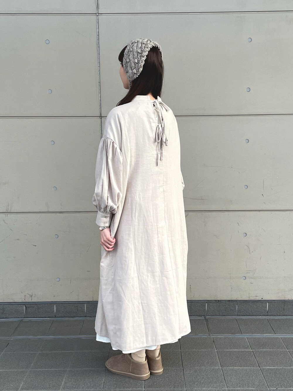 ベージュ系のワンピース、ブラウン系のトートバッグ、ベージュ系のブーツを着用したレディースの冬コーディネートの2枚目の写真