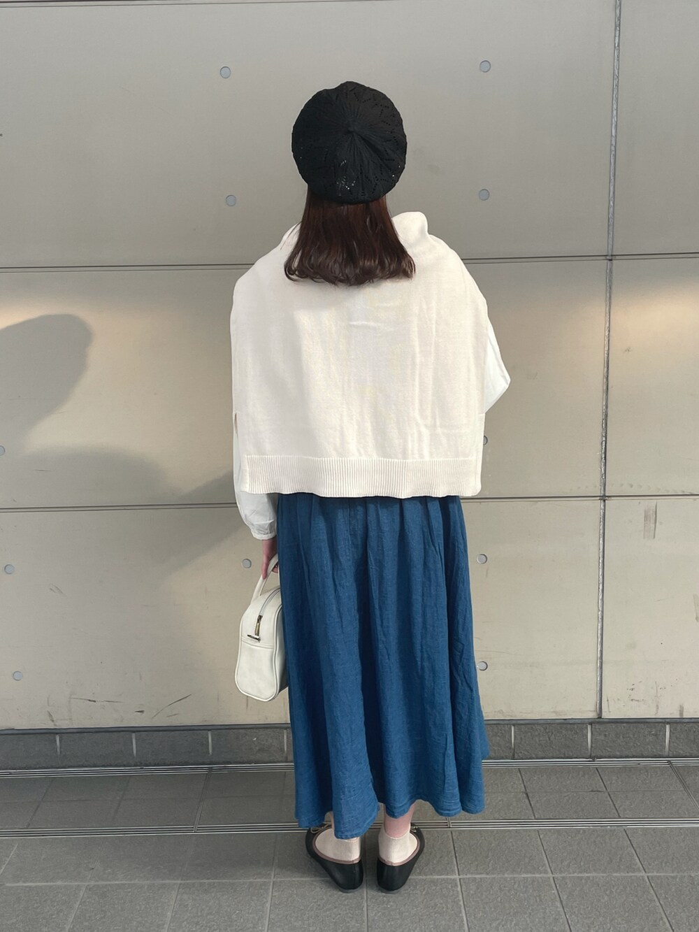 ホワイト系のカーディガン/ボレロ、ホワイト系のシャツ/ブラウス、ブルー系のスカートを着用したレディースの春コーディネートの3枚目の写真