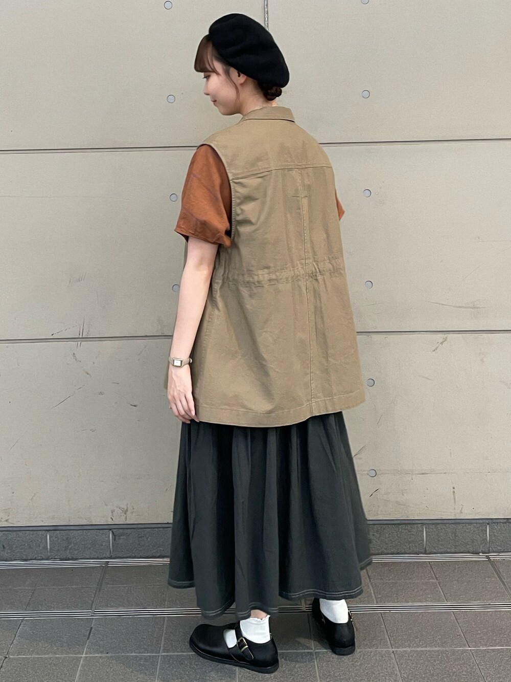 ブラウン系のシャツ/ブラウス、ベージュ系のベスト、ブラック系のスカートを着用したレディースの秋コーディネートの3枚目の写真