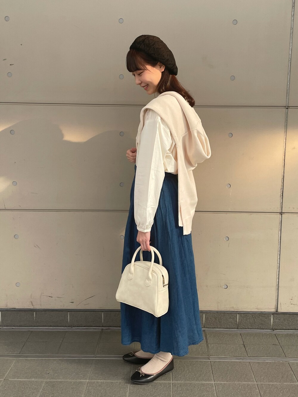 ホワイト系のカーディガン/ボレロ、ホワイト系のシャツ/ブラウス、ブルー系のスカートを着用したレディースの春コーディネートの2枚目の写真