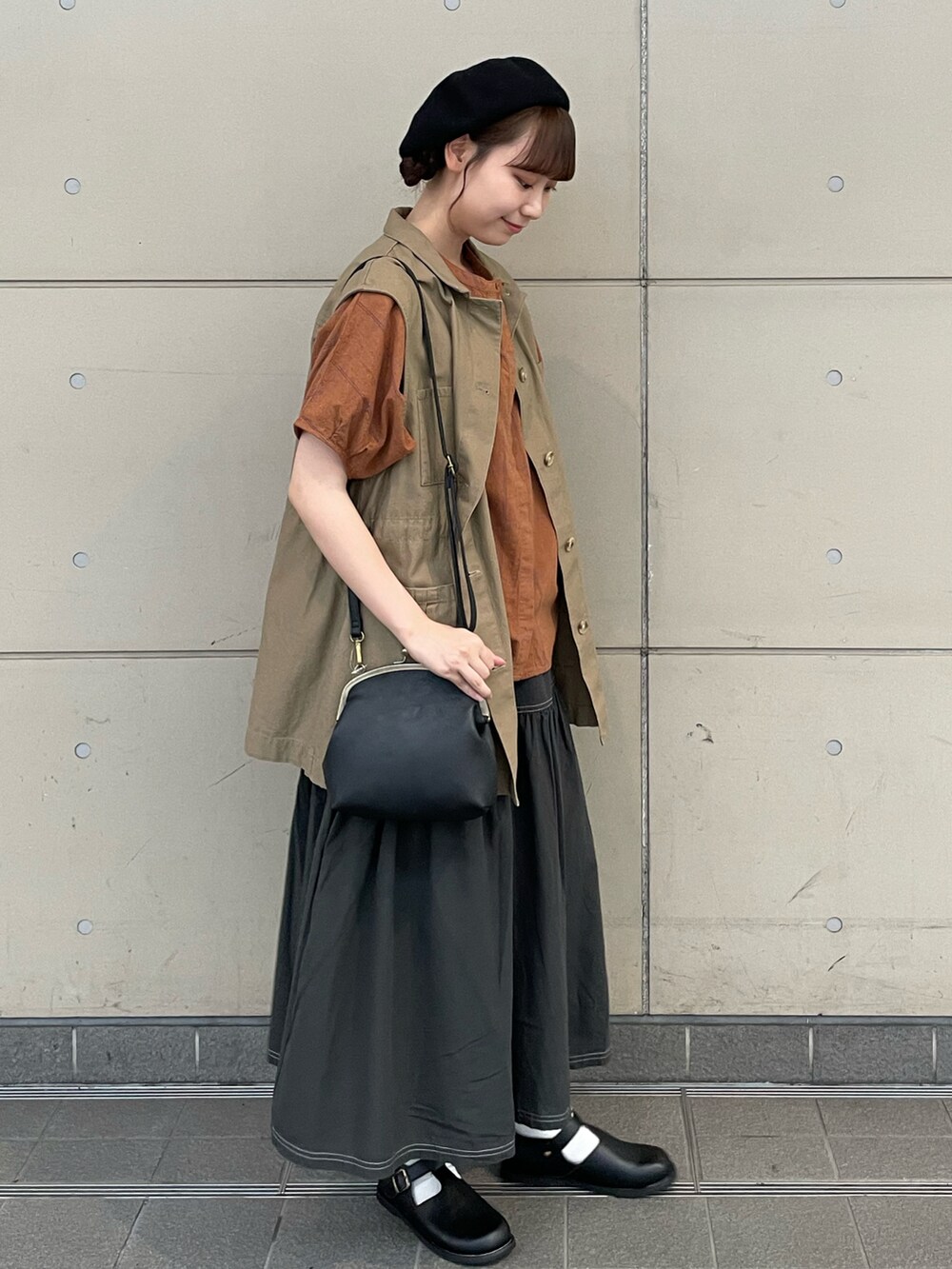 ブラウン系のシャツ/ブラウス、ベージュ系のベスト、ブラック系のスカートを着用したレディースの秋コーディネートの2枚目の写真