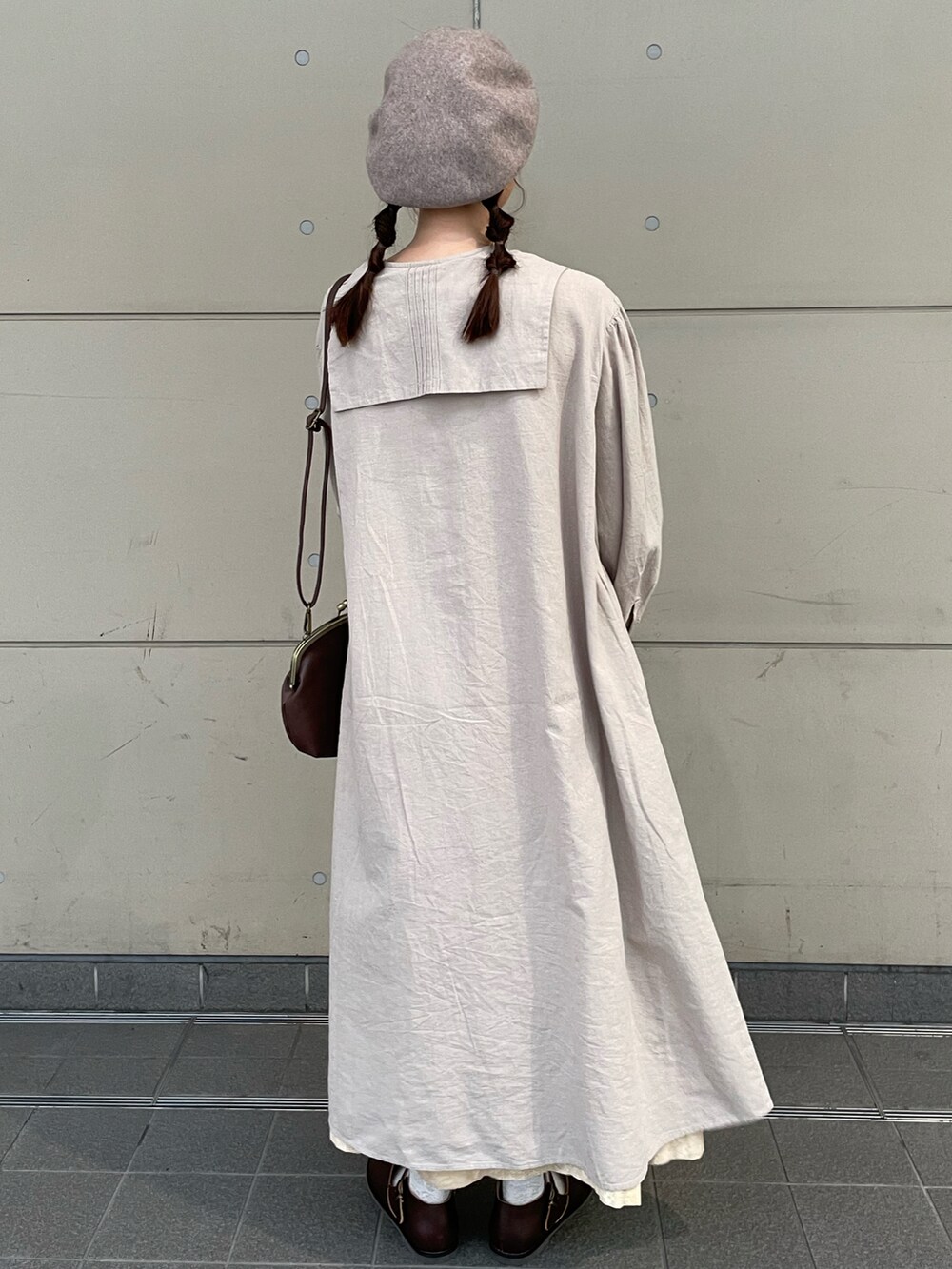 ベージュ系のワンピース、ホワイト系のスカート、ブラウン系のドレスシューズを着用したレディースの秋コーディネートの2枚目の写真