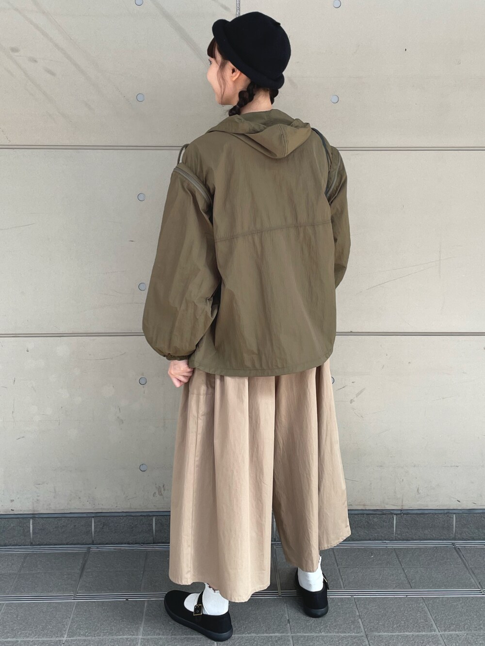 グリーン系のブルゾン、ホワイト系のTシャツ/カットソー、ベージュ系のその他パンツを着用したレディースの秋コーディネートの2枚目の写真